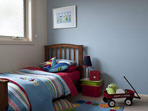 Baby_blue_feature_wall_childs_bedroom_cream_widow_sills_blue_red_green_striped_blankets_pillows